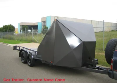 A car trailer with a custom nose cone attached to it
