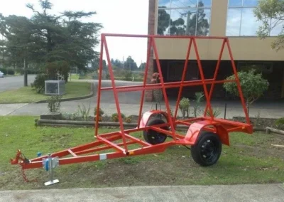 A red trailer is parked in fron of a building