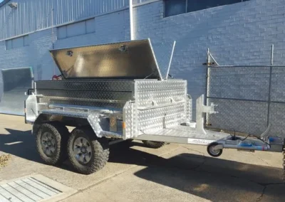 A trailer with a canopy on top of it is parked in front of a building